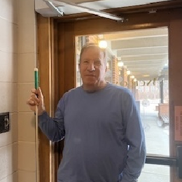 Bob Burns facing the camera while holding a cane.
